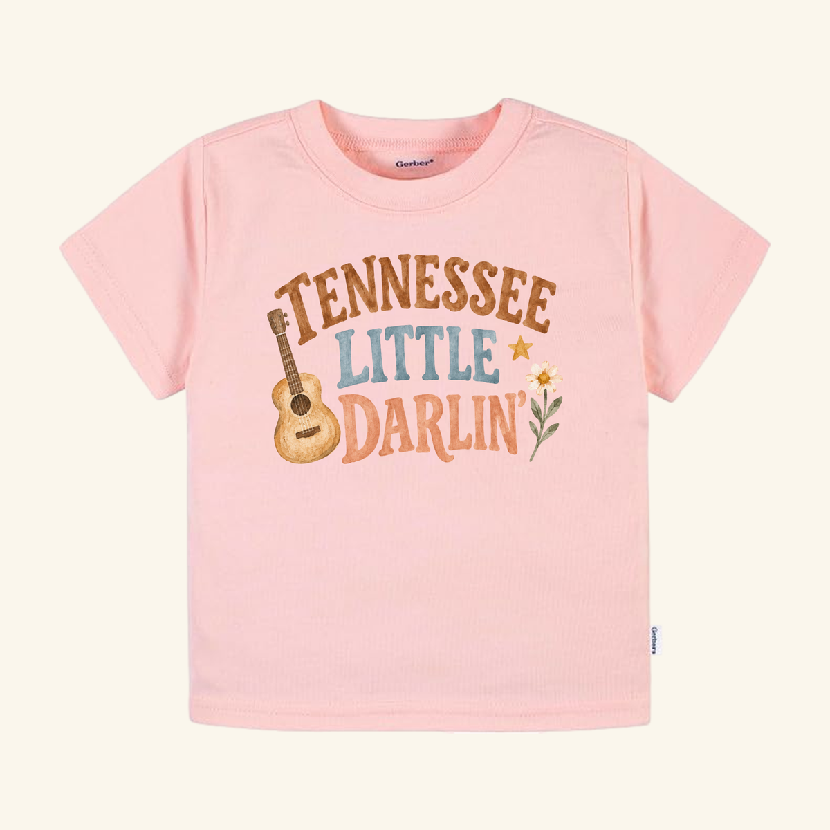 Light pink Toodleroos Tennessee Toddler Shirt – Little Darlin’ Guitar Country Tee featuring an acoustic guitar, a daisy, and the text Tennessee Little Darlin.