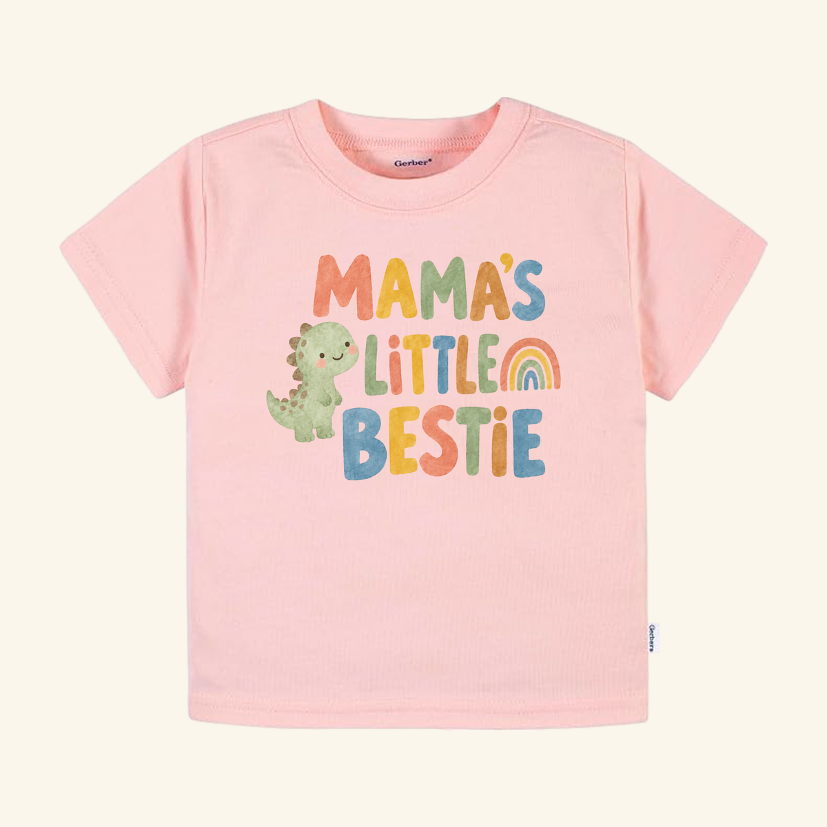Mama’s Little Bestie Toddler Shirt – Cute Dinosaur Mom Tee in pink, featuring a green dinosaur, a rainbow, and the text Mama’s Little Bestie.
