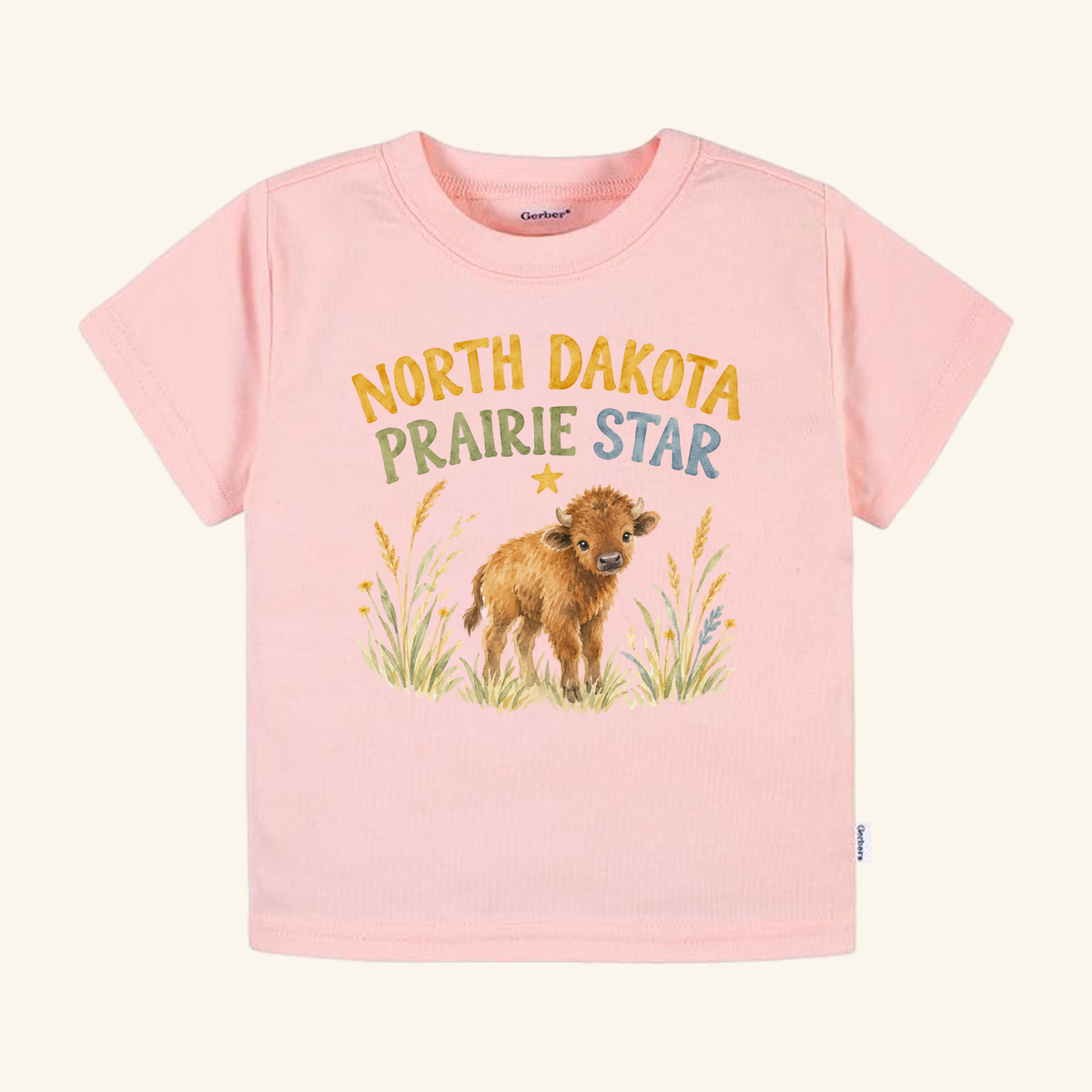Light pink North Dakota Toddler Shirt – Prairie Star Baby Bison Tee featuring a bison calf in a field of grass.