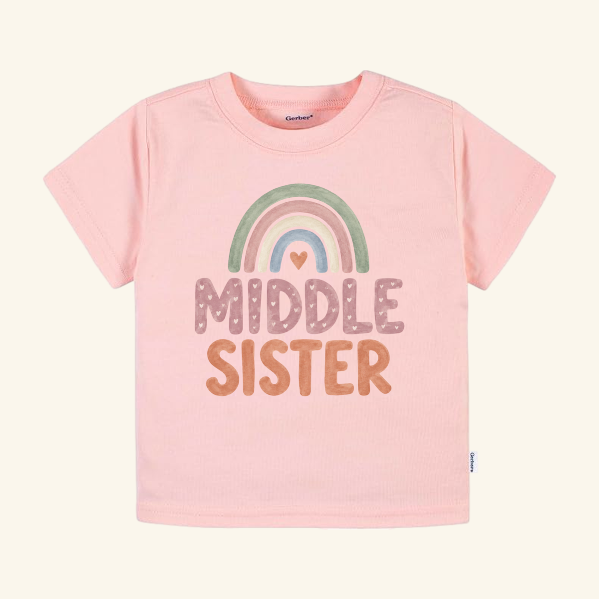 Light pink Middle Sister Toddler Shirt – Boho Rainbow Sibling Tee featuring a boho rainbow graphic and the text MIDDLE SISTER.