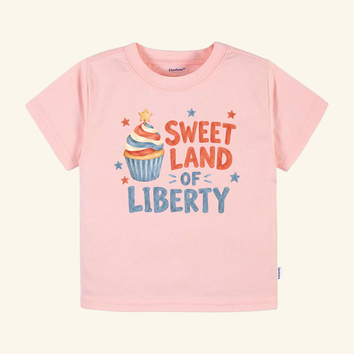 Light pink Toodleroos Sweet Land of Liberty Toddler Shirt featuring a red, white, and blue cupcake graphic with the text Sweet Land of Liberty surrounded by small stars.