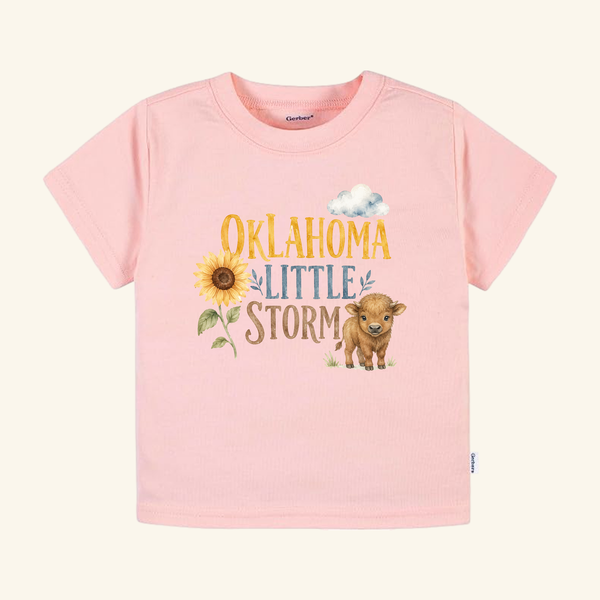 Light pink Oklahoma Toddler Shirt – Little Storm Sunflower & Baby Bison Tee featuring a graphic of a sunflower, a baby bison, a cloud, and the text OKLAHOMA LITTLE STORM.