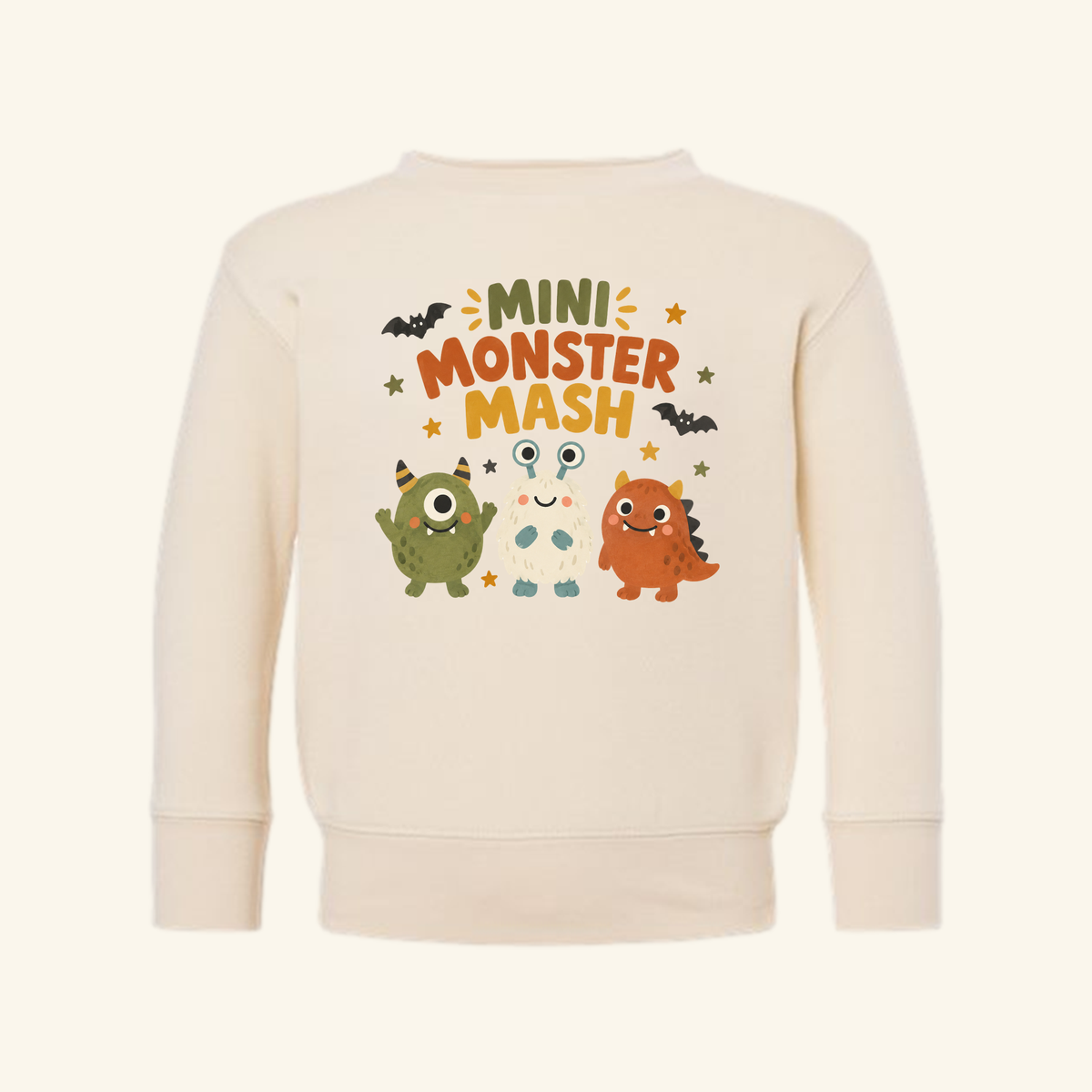 Cream-colored Mini Monster Mash Toddler Sweatshirt featuring three cartoon monsters, bats, stars, and the text MINI MONSTER MASH.