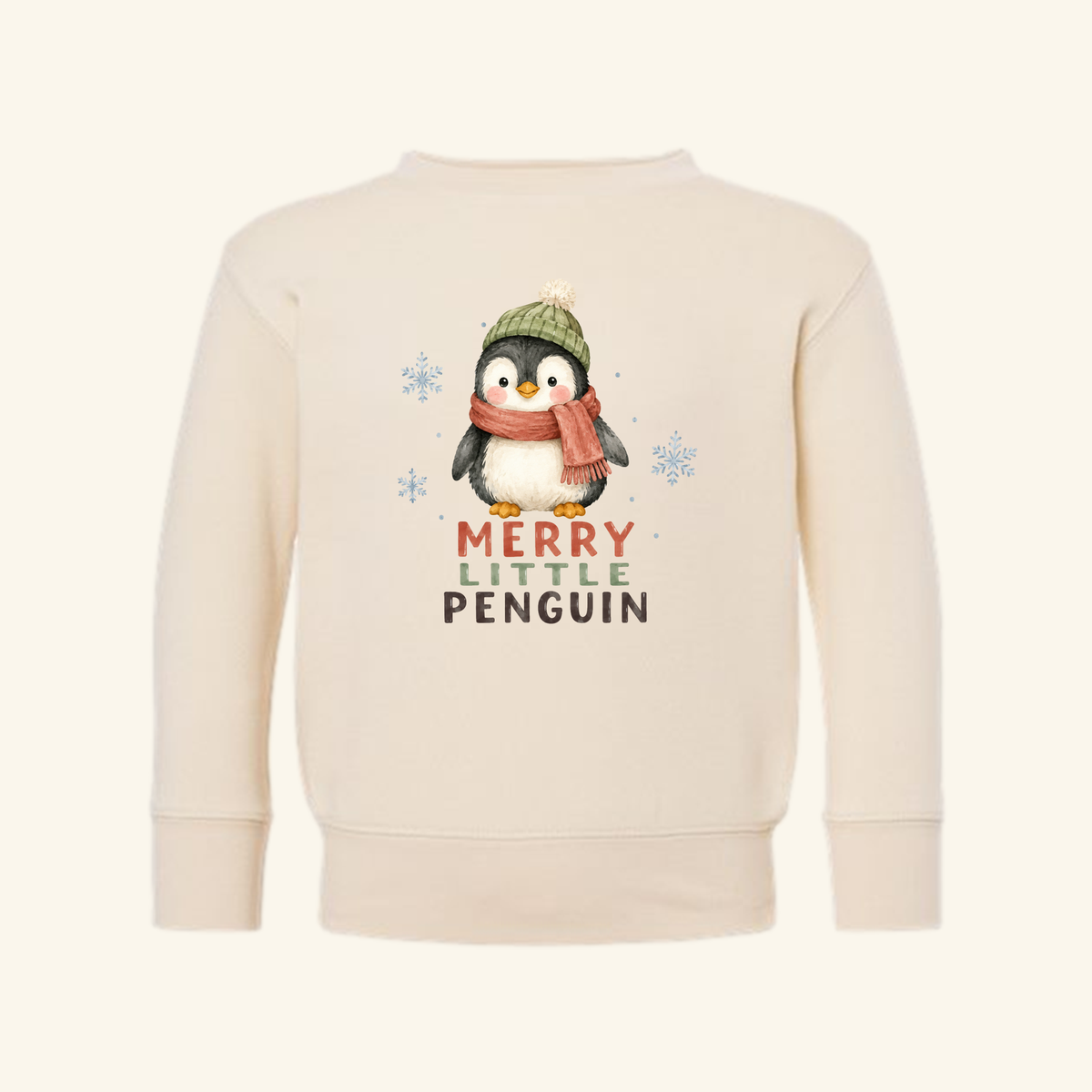 Merry Little Penguin Toddler Sweatshirt – Cute Christmas Pullover in cream with a penguin wearing a green beanie and red scarf, featuring the text Merry Little Penguin and light blue snowflakes.