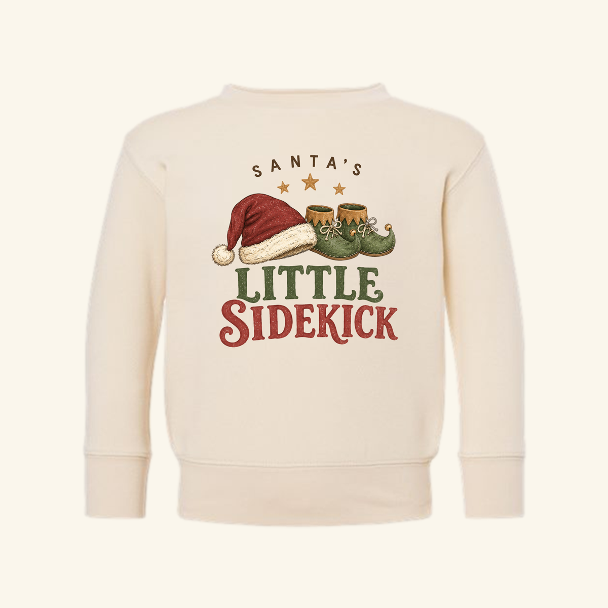 Cream-colored Santa’s Little Sidekick Toddler Sweatshirt – Christmas Elf Pullover featuring a graphic of a Santa hat and elf shoes.