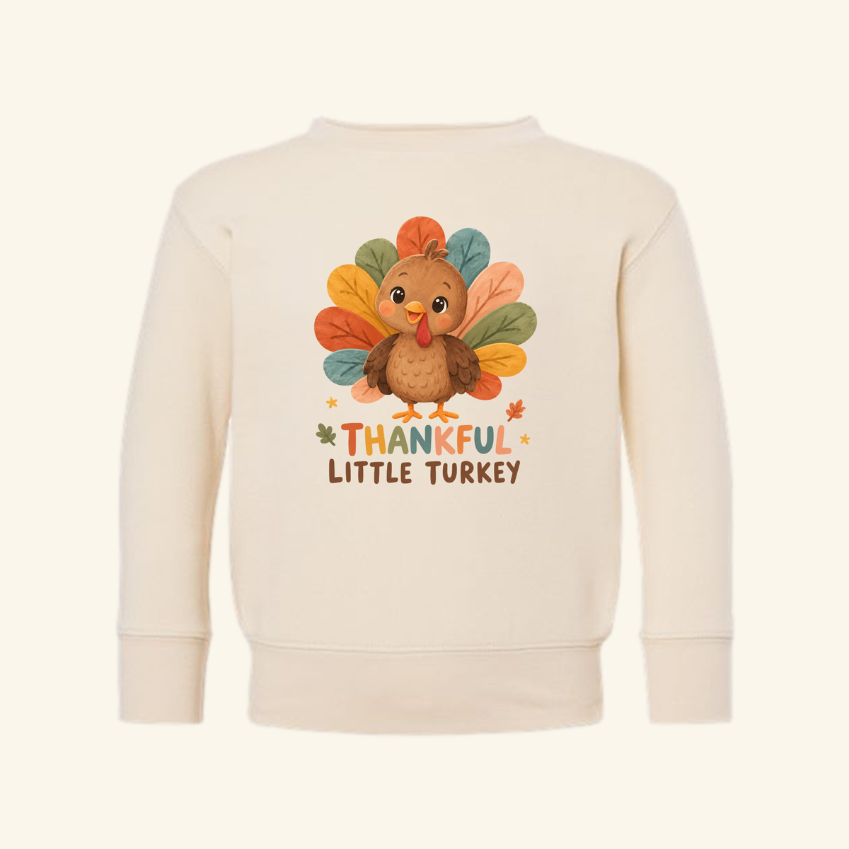 Cream-colored Thankful Little Turkey Toddler Sweatshirt – Thanksgiving Pullover featuring a cartoon turkey and the text Thankful Little Turkey.