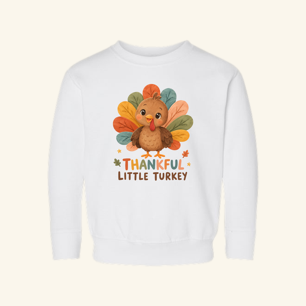 White Thankful Little Turkey Toddler Sweatshirt featuring an illustration of a cute turkey with colorful tail feathers and the text THANKFUL LITTLE TURKEY.
