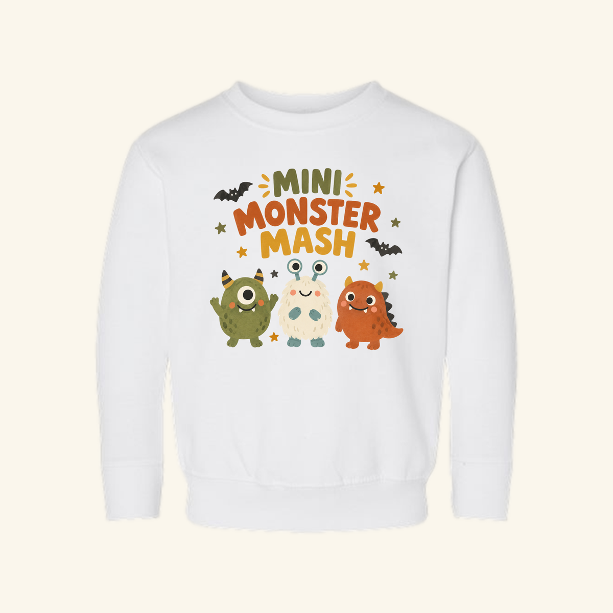Toodleroos Mini Monster Mash Toddler Sweatshirt, a white long-sleeve top featuring a graphic of three cute monsters and the text Mini Monster Mash.