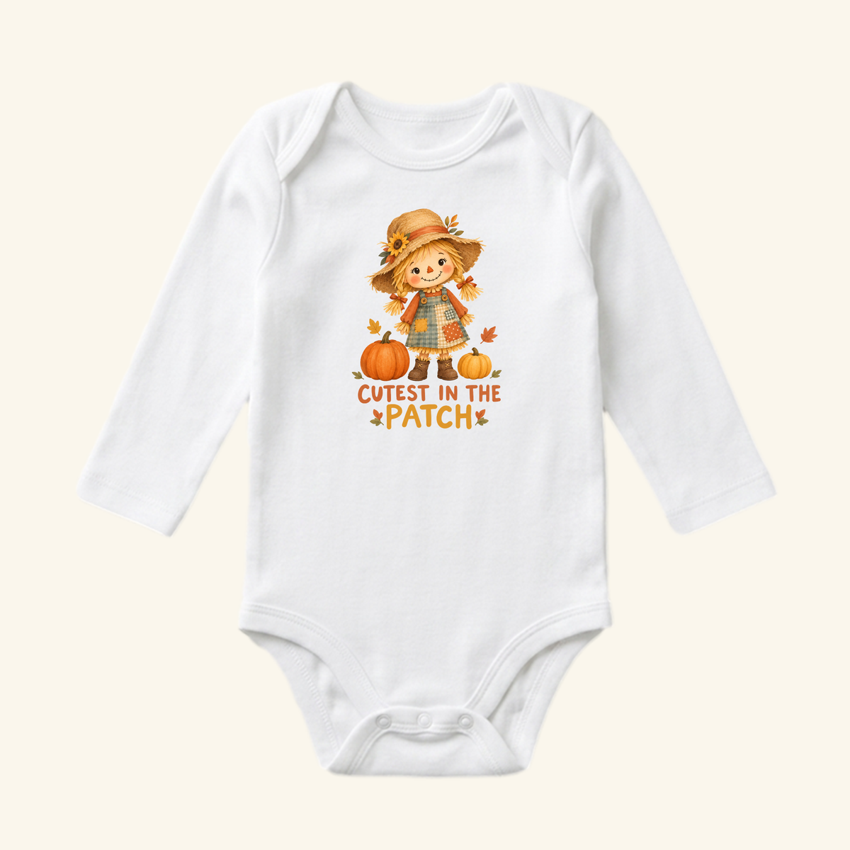 Toodleroos Cutest in the Patch Baby Onesie featuring a white long-sleeve bodysuit with a scarecrow illustration, two pumpkins, and the text Cutest in the Patch.