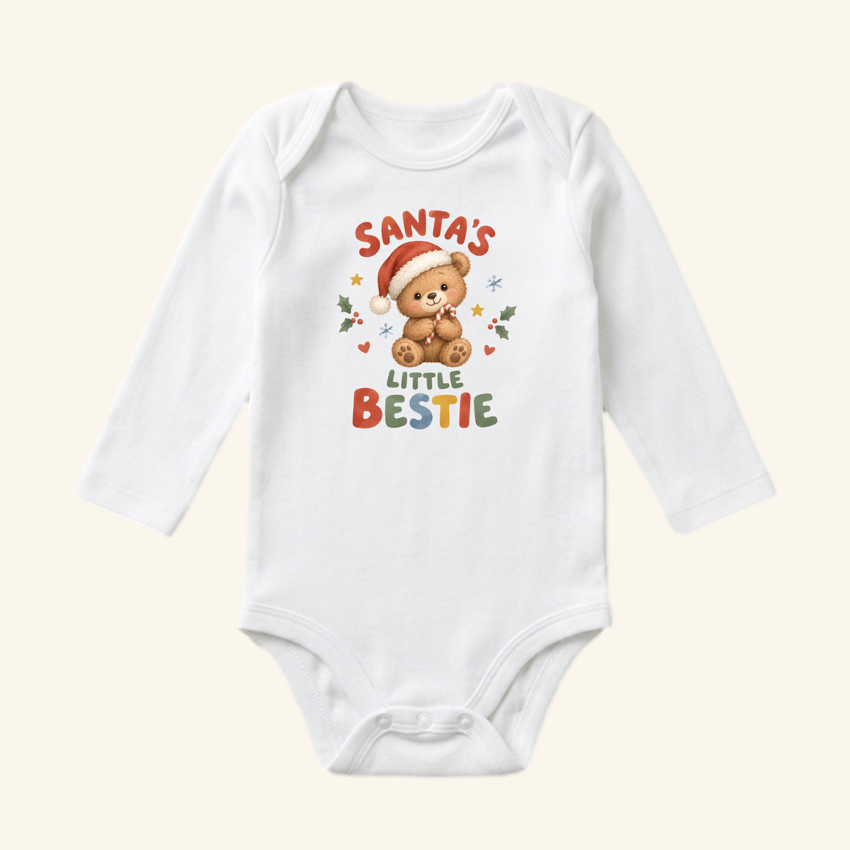Toodleroos Santa’s Little Bestie Baby Onesie – Teddy Bear Christmas Bodysuit, a white long-sleeved garment featuring a teddy bear in a Santa hat holding a candy cane, surrounded by the text Santa’s Little Bestie, holly, and stars.
