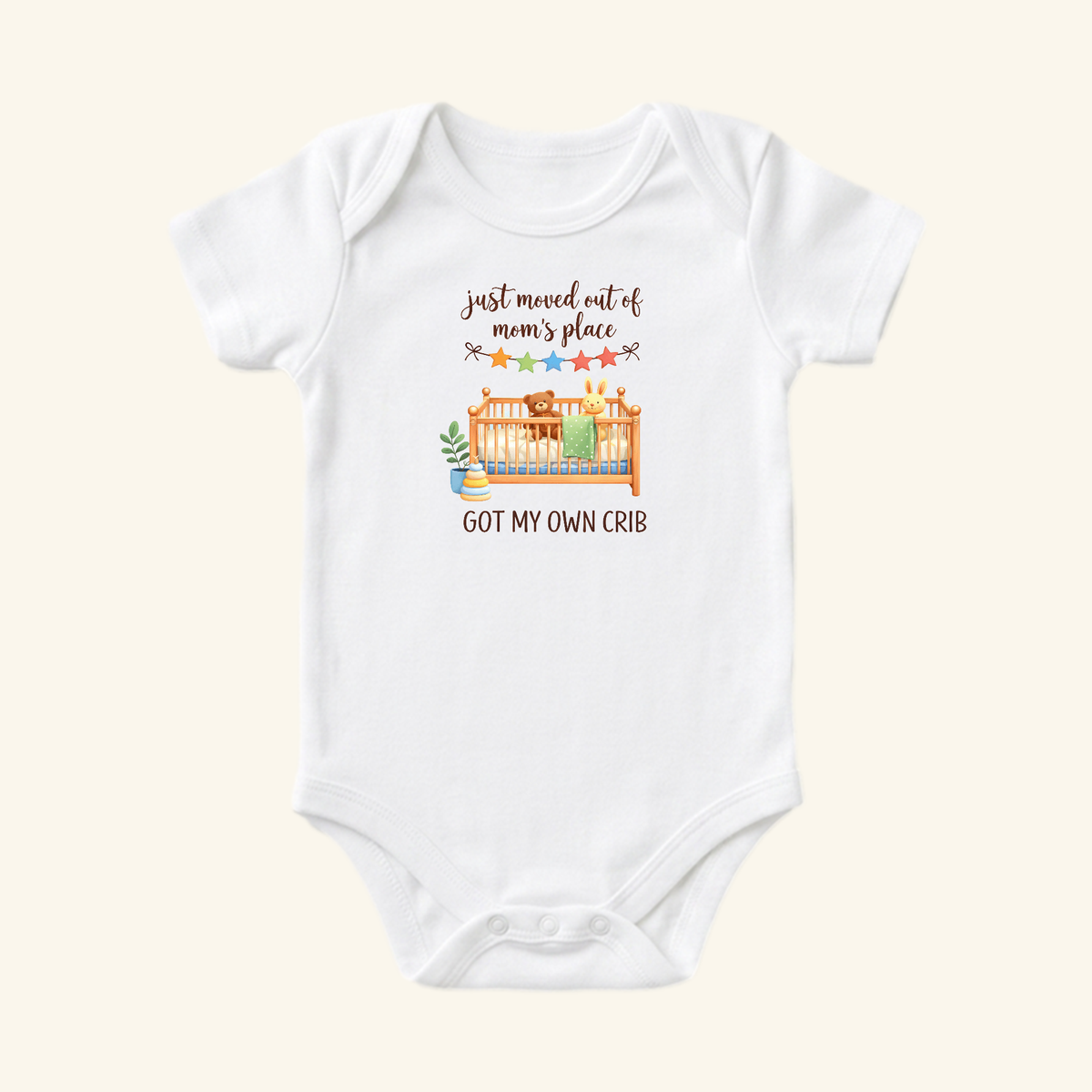 Funny Baby Onesie – Got My Own Crib Bodysuit: a white baby bodysuit featuring a graphic of a crib with a teddy bear and rabbit, with the text just moved out of mom’s place and GOT MY OWN CRIB.