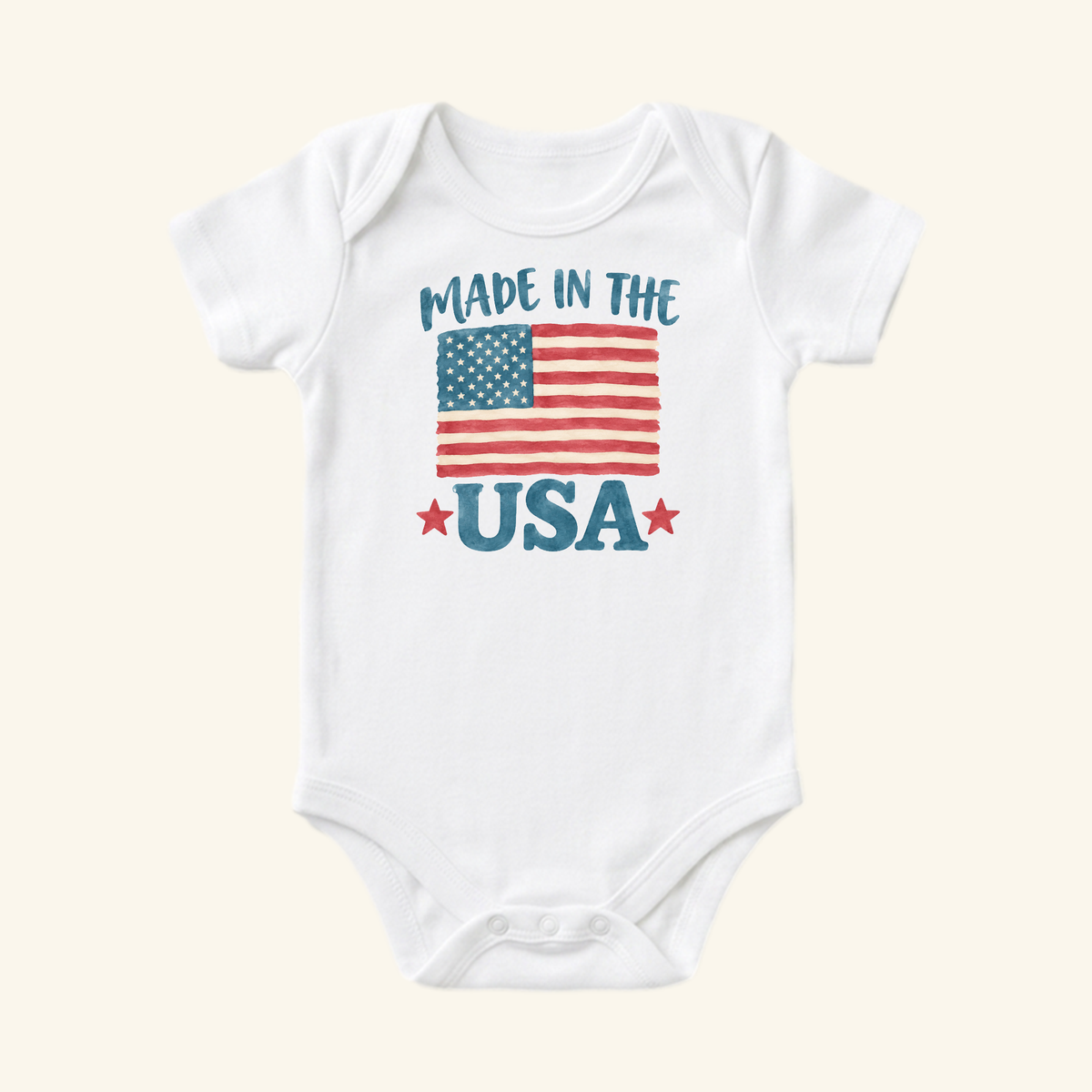 Toodleroos Made in the USA Baby Onesie – Patriotic American Flag Bodysuit featuring a watercolor-style American flag graphic and MADE IN THE USA text with red stars.