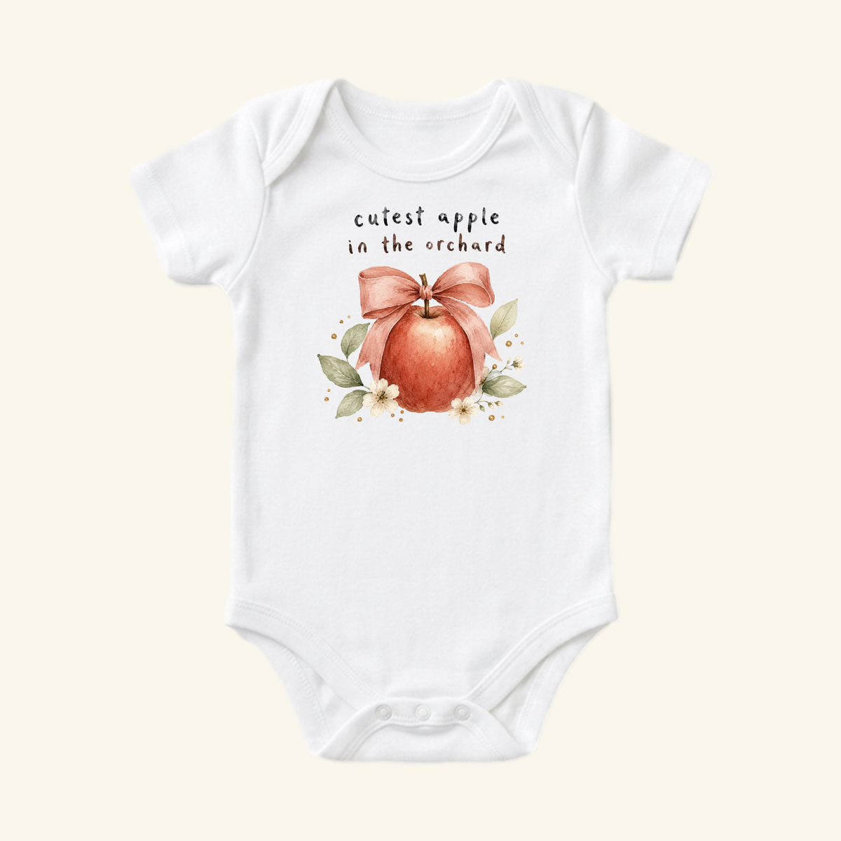 Toodleroos Cutest Apple in the Orchard Baby Onesie – Fall Apple Bow Bodysuit, featuring a watercolor apple with a pink bow and leaves, with the text cutest apple in the orchard on a white short-sleeved bodysuit.