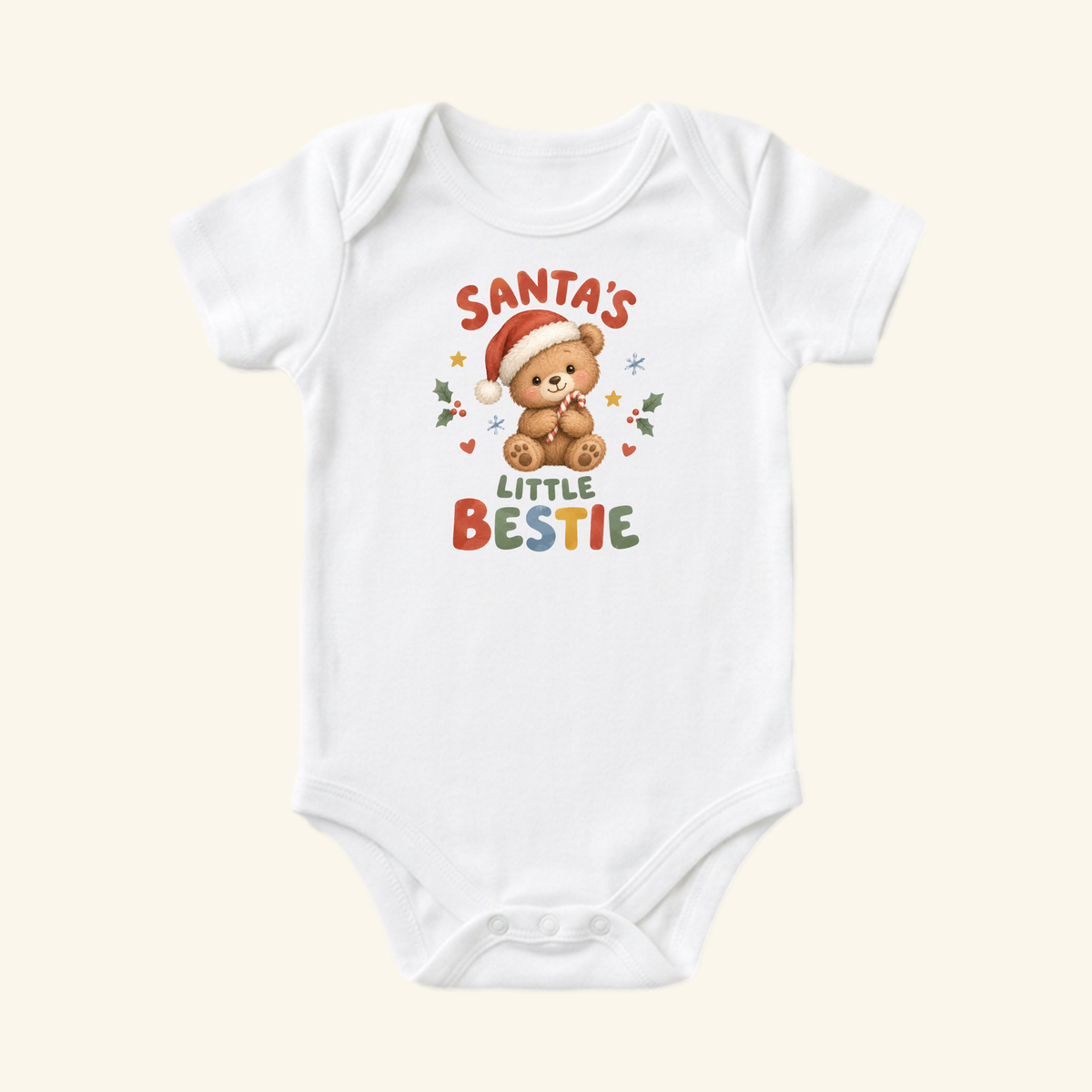 White Toodleroos Santa’s Little Bestie Baby Onesie – Teddy Bear Christmas Bodysuit featuring a teddy bear in a Santa hat holding a candy cane, with Santa’s Little Bestie printed above and below the bear.
