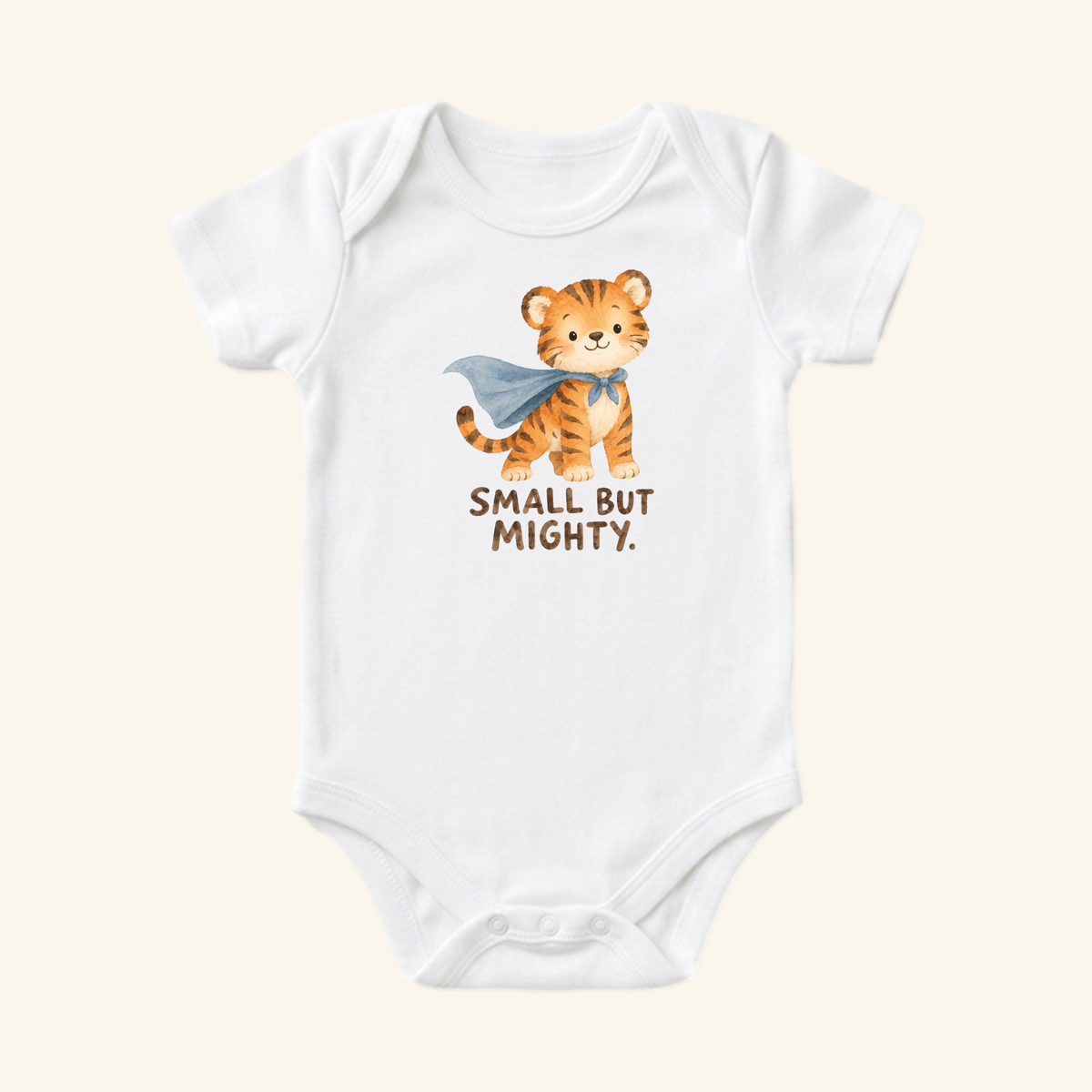 Toodleroos Small But Mighty Baby Onesie – Superhero Tiger Bodysuit featuring a watercolor illustration of a superhero tiger wearing a blue cape, with the text SMALL BUT MIGHTY underneath.