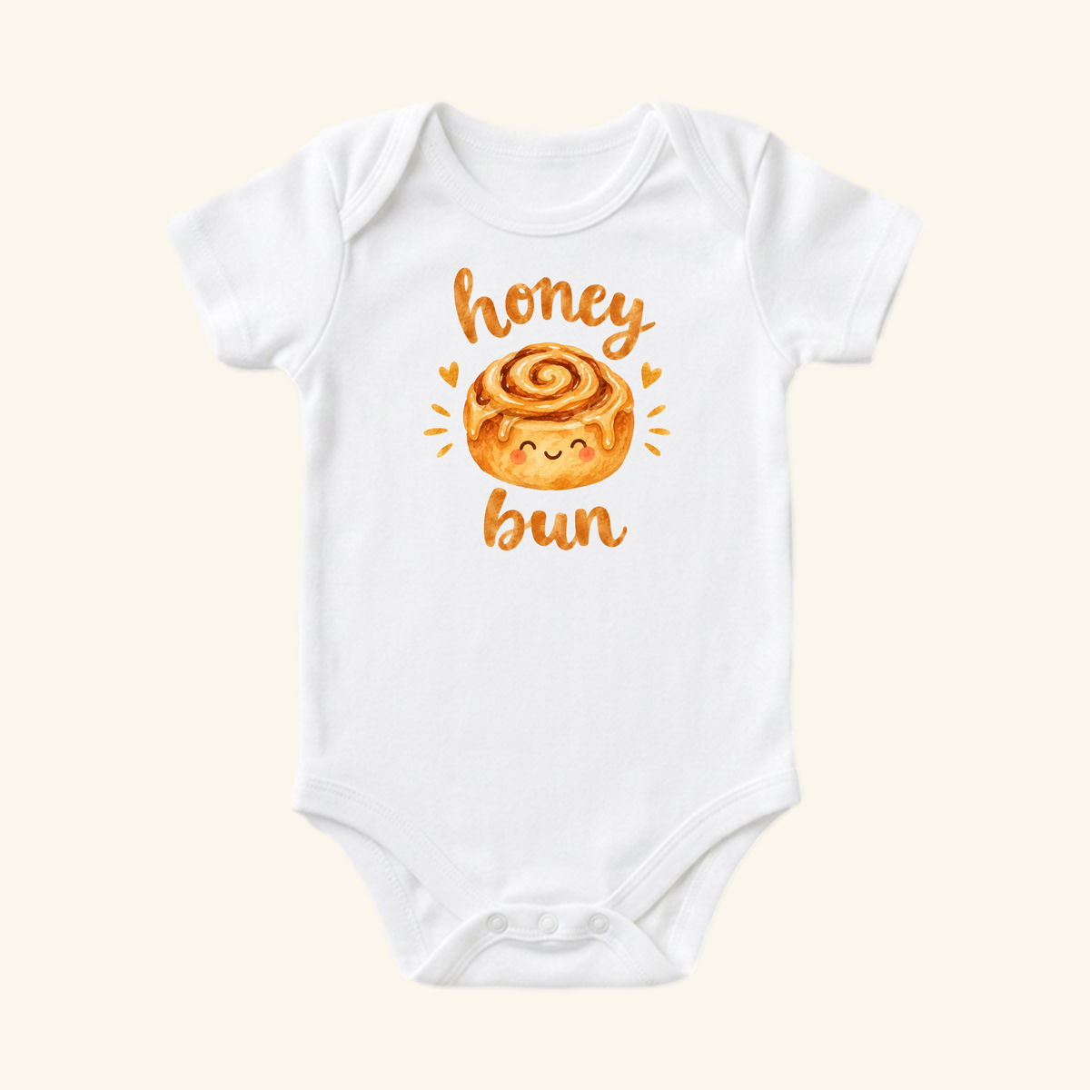 Dress your little sweetie in the Toodleroos Cute Baby Onesie – Honey Bun Cinnamon Roll Bodysuit, featuring a smiling cinnamon roll and honey bun script—a perfectly adorable outfit!.