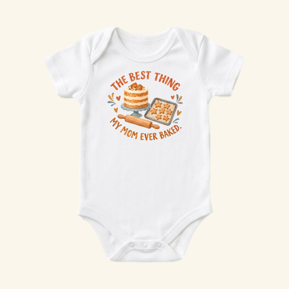 White Best Thing My Mom Baked Baby Onesie – Cute Mom Baking Bodysuit featuring an illustration of a cake, star-shaped cookies, and a rolling pin with the text The best thing my mom ever baked.