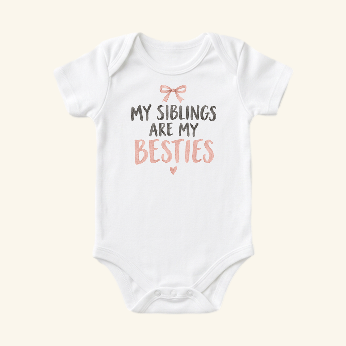 Toodleroos My Siblings Are My Besties Baby Onesie – Pink Bow Sibling Bodysuit featuring a pink bow icon above the text MY SIBLINGS ARE MY BESTIES and a small pink heart.