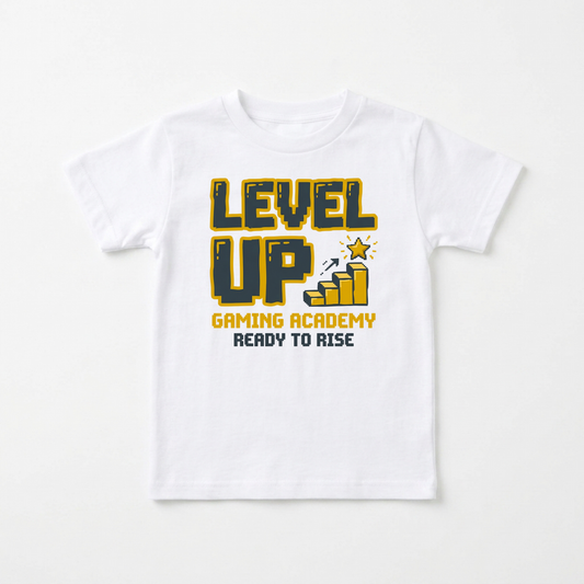 A white short-sleeve kids' t-shirt with a graphic on the front that reads 'LEVEL UP GAMING ACADEMY READY TO RISE' in yellow and dark blue pixel-style lettering, shown against a plain white background.