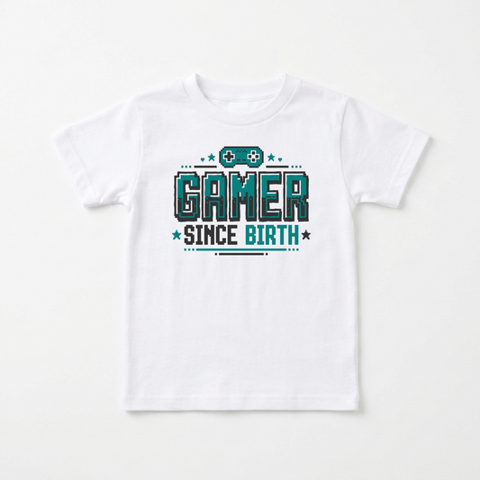 A white short-sleeve kids' t-shirt with a graphic print on the front that reads 'GAMER SINCE BIRTH' in teal and black pixelated text, accompanied by a small video game controller icon above, shown on a clean white background.