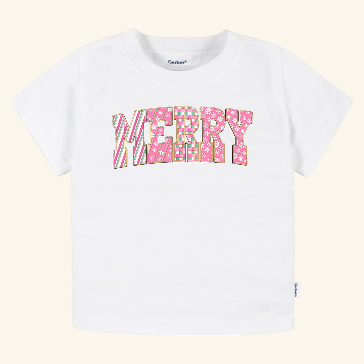 Toodleroos Merry Toddler Shirt – Pink Candy Cane Christmas Tee is a white short-sleeved toddler t-shirt featuring the word MERRY in pink, patterned block letters.