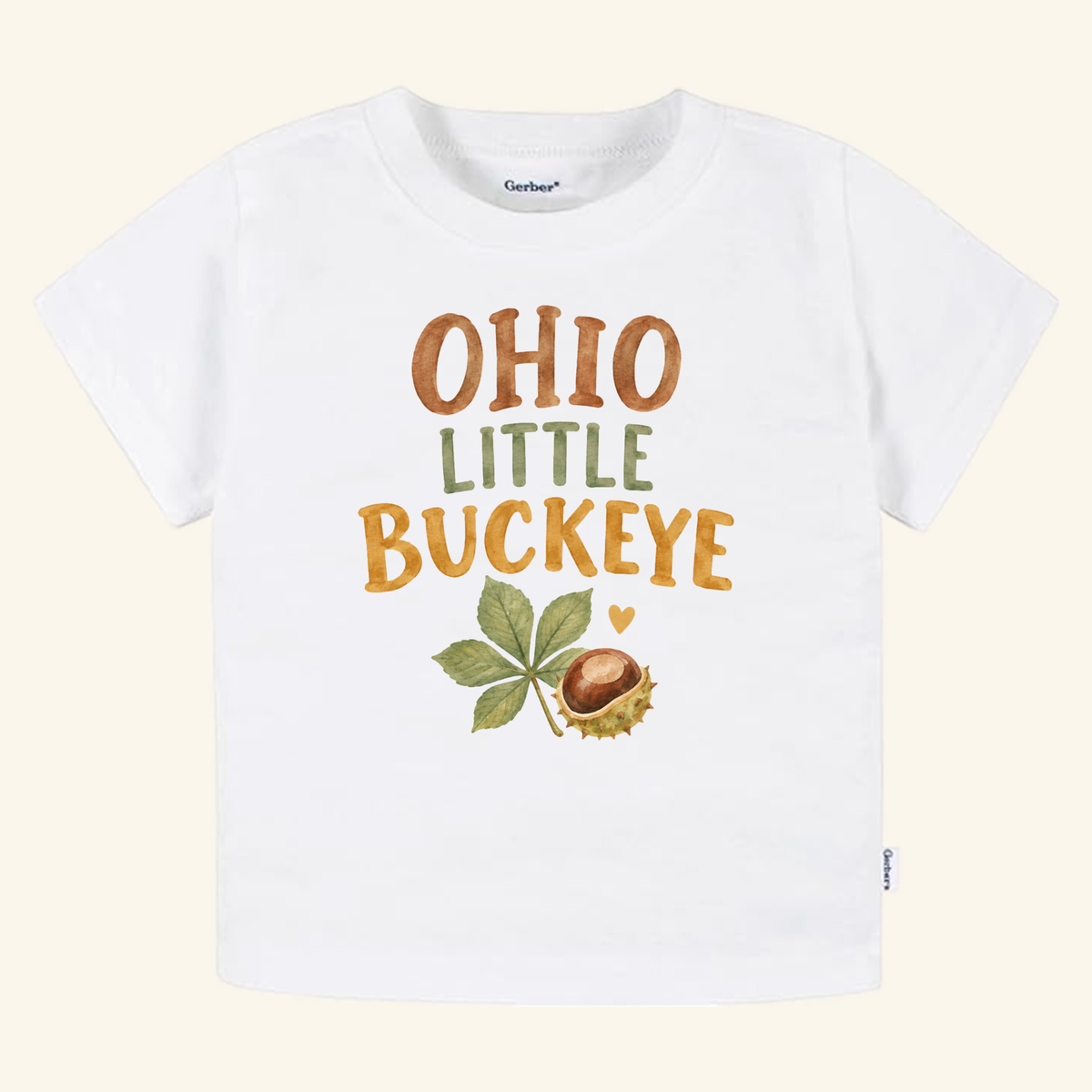 Ohio Toddler Shirt – Little Buckeye Watercolor Nut & Leaf Tee featuring watercolor text that reads OHIO LITTLE BUCKEYE above an illustration of a buckeye nut and leaf on a white toddler t-shirt.