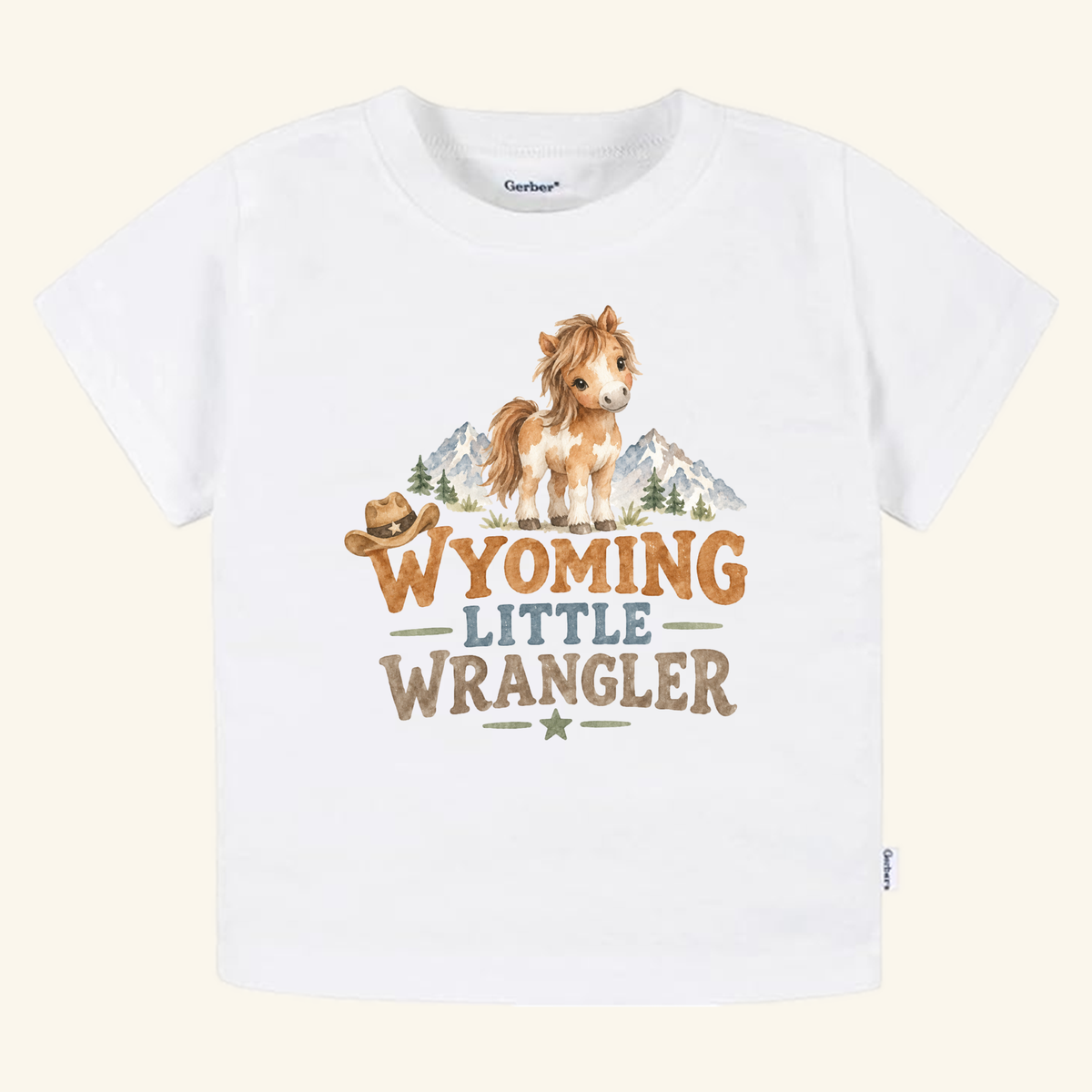 Wyoming Toddler Shirt – Little Wrangler Western Pony Tee featuring a white toddler t-shirt with a watercolor illustration of a pony, mountains, and a cowboy hat, with text that reads Wyoming Little Wrangler.