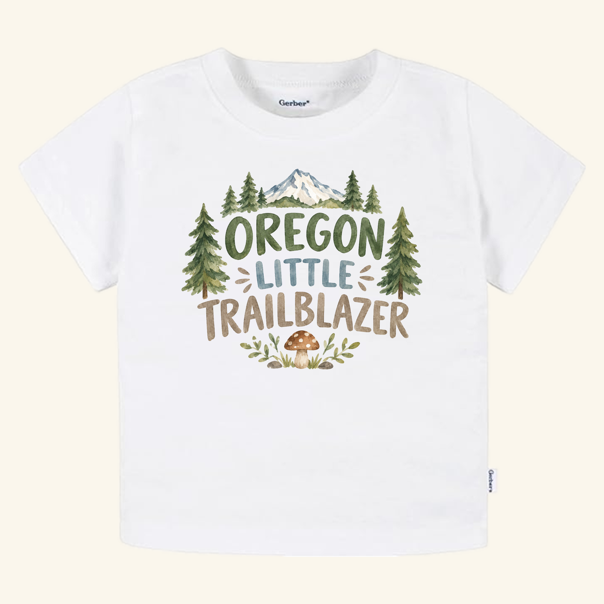 White Toodleroos Oregon Toddler Shirt – Little Trailblazer Mountain Forest Tee featuring a watercolor mountain, pine tree, and mushroom graphic, with the text Oregon Little Trailblazer.
