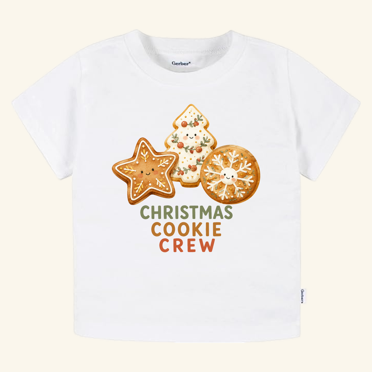 White Toodleroos Christmas Cookie Crew Toddler Shirt featuring illustrations of three decorated holiday cookies with smiling faces and the text CHRISTMAS COOKIE CREW underneath.