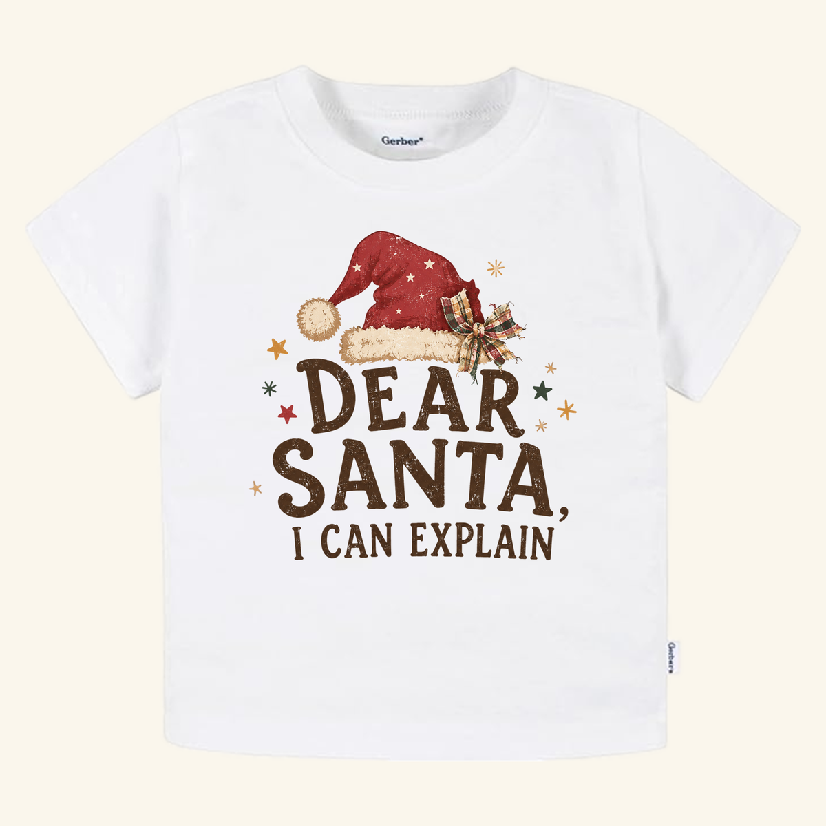 White Toodleroos Dear Santa, I Can Explain Toddler Shirt – Funny Christmas Santa Hat Tee featuring a Santa hat graphic and the text Dear Santa, I can explain in brown lettering.