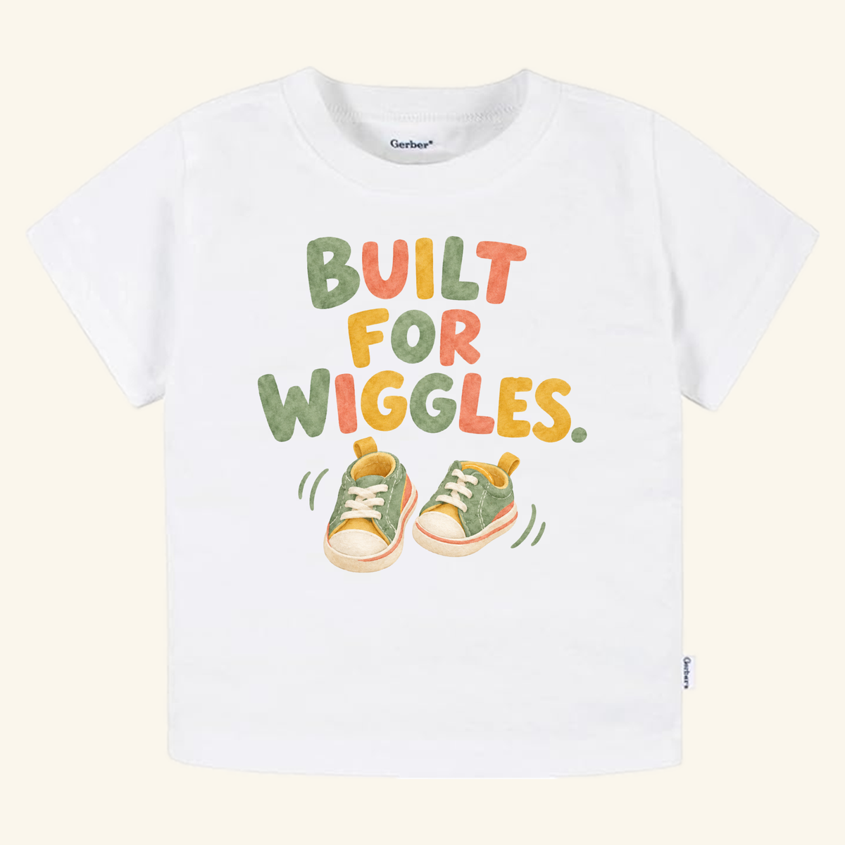 Toodleroos Built for Wiggles Toddler Shirt featuring white fabric with the text BUILT FOR WIGGLES above an illustration of green and yellow sneakers.