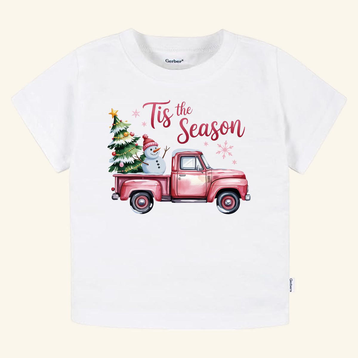 Toodleroos Pink Christmas Truck Toddler Shirt – ’Tis the Season Snowman Tee featuring a pink pickup truck carrying a snowman and a decorated Christmas tree with the text Tis the Season above it.