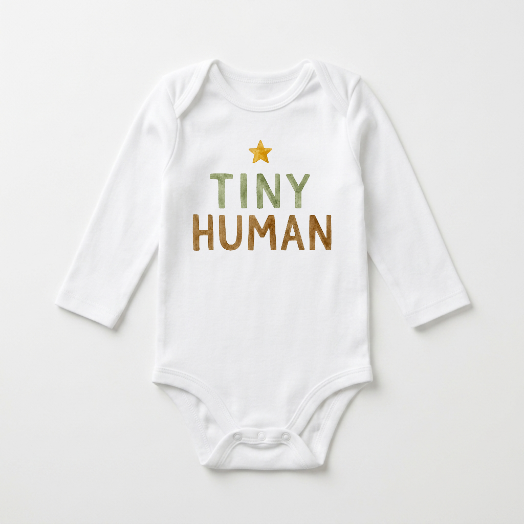 The Toodleroos Gender-Neutral Long-Sleeve Baby Onesie – Tiny Human Graphic Bodysuit is a minimalist white bodysuit featuring a yellow star and the words “TINY HUMAN” in green and brown on the front, laid flat on a white surface. This adorable piece is perfect as a gender-neutral choice for your little one.