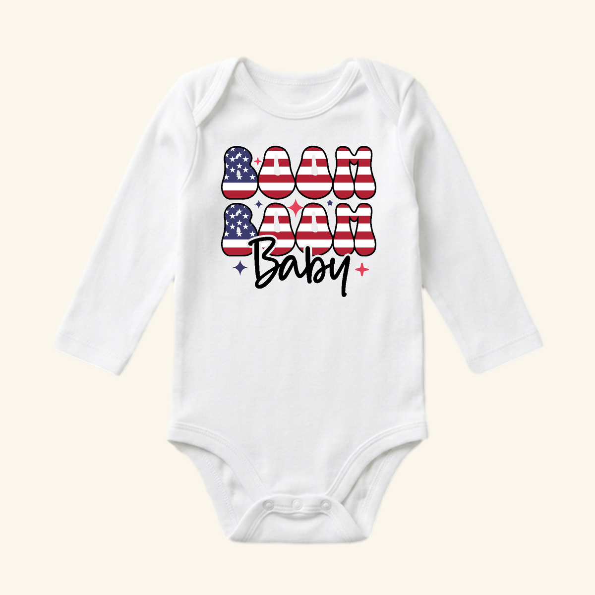 Toodleroos 4th of July Baby Onesie – Boom Boom Baby Patriotic Bodysuit featuring white long sleeves and the text BOOM BABY in a flag print with small star icons.
