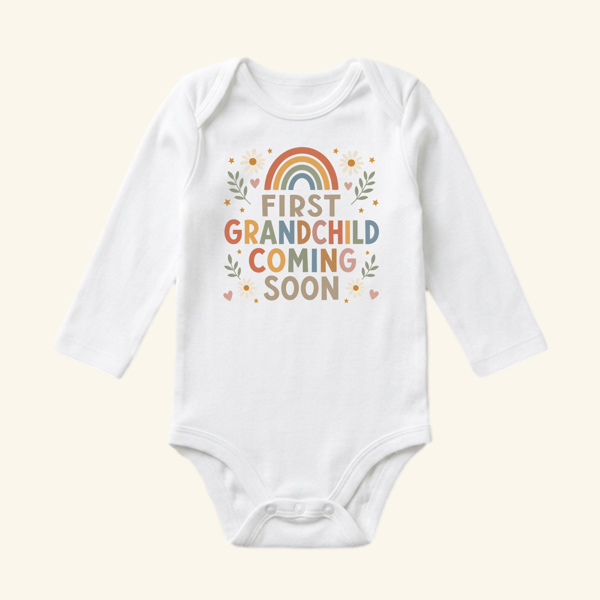 White long-sleeved First Grandchild Announcement Baby Onesie – Coming Soon Bodysuit featuring a floral rainbow graphic and the text FIRST GRANDCHILD COMING SOON, perfect for a grandparent pregnancy reveal.
