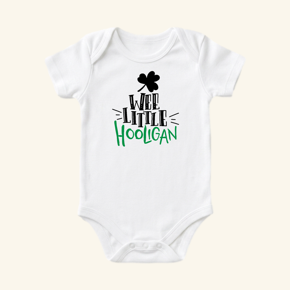 St. Patrick’s Day Baby Onesie – Wee Little Hooligan Bodysuit featuring a white bodysuit with a black shamrock and the text Wee Little Hooligan in black and green.