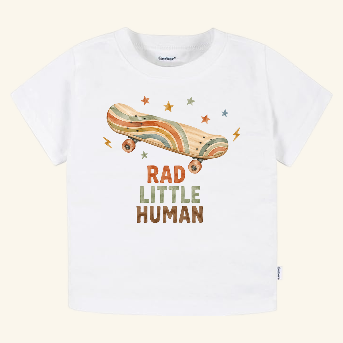 Toodleroos Skateboard Toddler Shirt – Rad Little Human Retro Tee featuring a white t-shirt with a retro skateboard graphic, rainbow stripes, stars, lightning bolts, and the text RAD LITTLE HUMAN.
