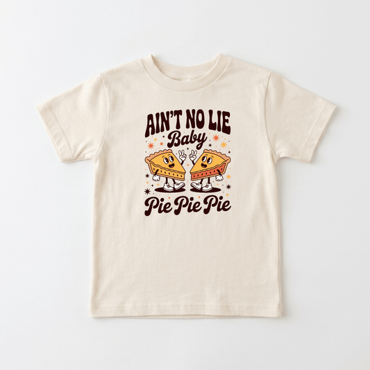 Dress your little one in the Toodleroos “Funny Toddler Thanksgiving Shirt – Ain’t No Lie Baby Pie Pie Pie Tee,” a cream-colored tee featuring two cartoon pie slices and the playful phrase “Ain’t No Lie Baby Pie Pie Pie”—the perfect cute and funny Thanksgiving outfit for kids!.