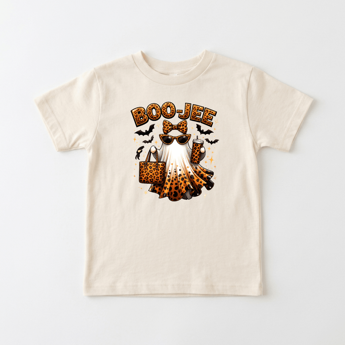 The Toodleroos Boo-Jee Ghost Toddler Girls Shirt – Leopard Print Halloween Tee features a cream base adorned with a stylish ghost sporting sunglasses, a leopard print headband, and holding a matching leopard print bag. The word “BOO-JEE” appears above the design, surrounded by playful bats and stars, making this trendy shirt the perfect Halloween outfit for little ones who want to stand out in style!.