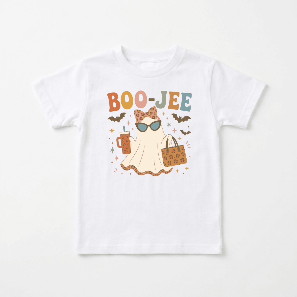 The Toodleroos Toddler Girl Halloween Shirt – Boo-Jee Ghost Short-Sleeve Tee showcases a playful white tee adorned with a graphic of a ghost sporting sunglasses, holding a drink and handbag, and surrounded by bats and stars. The colorful “BOO-JEE” text above the ghost adds extra charm, making this cute shirt the perfect Halloween outfit for your little one. Fun and festive, it’s an ideal choice for any spooky celebration.