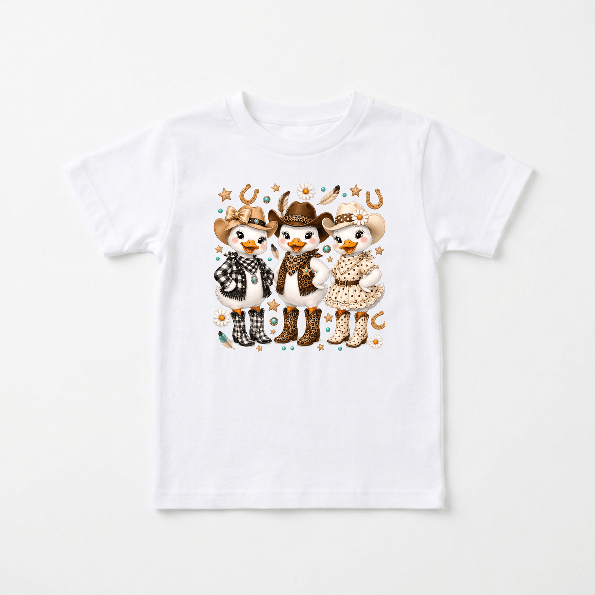 Introducing the Cowgirl Duck Trio Kids Shirt – Country Girls Tee by Toodleroos! This white shirt features three cartoon animals—each adorned with cowboy hats, boots, and playful patterns—standing together amidst stars, horseshoes, and western-inspired accents. Perfect for little ones who love fun country styles or playful western kids shirts, this Toodleroos tee brings a charming touch of the wild west to any child’s wardrobe.