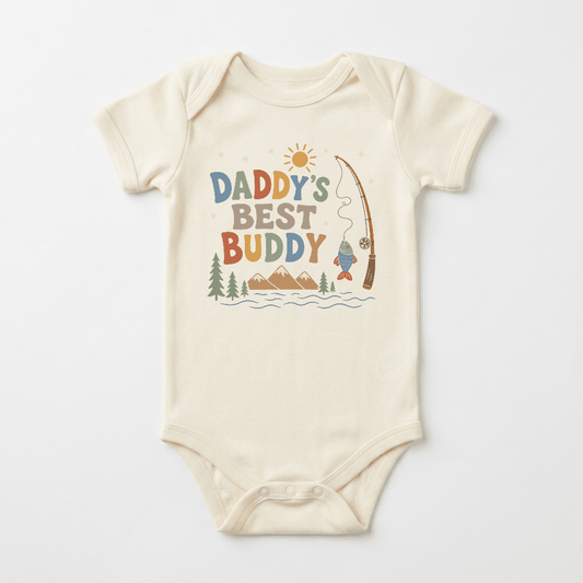 Dress your little one in adventure-ready style with the Toodleroos Baby Boy Fishing Onesie – Daddy’s Best Buddy Short-Sleeve Bodysuit. This cozy cream-colored bodysuit features playful “Daddy’s Best Buddy” text on the front, along with charming illustrations of a sun, mountains, pine trees, water, and a fishing pole catching a fish—perfect for babies who love exploring with dad!.