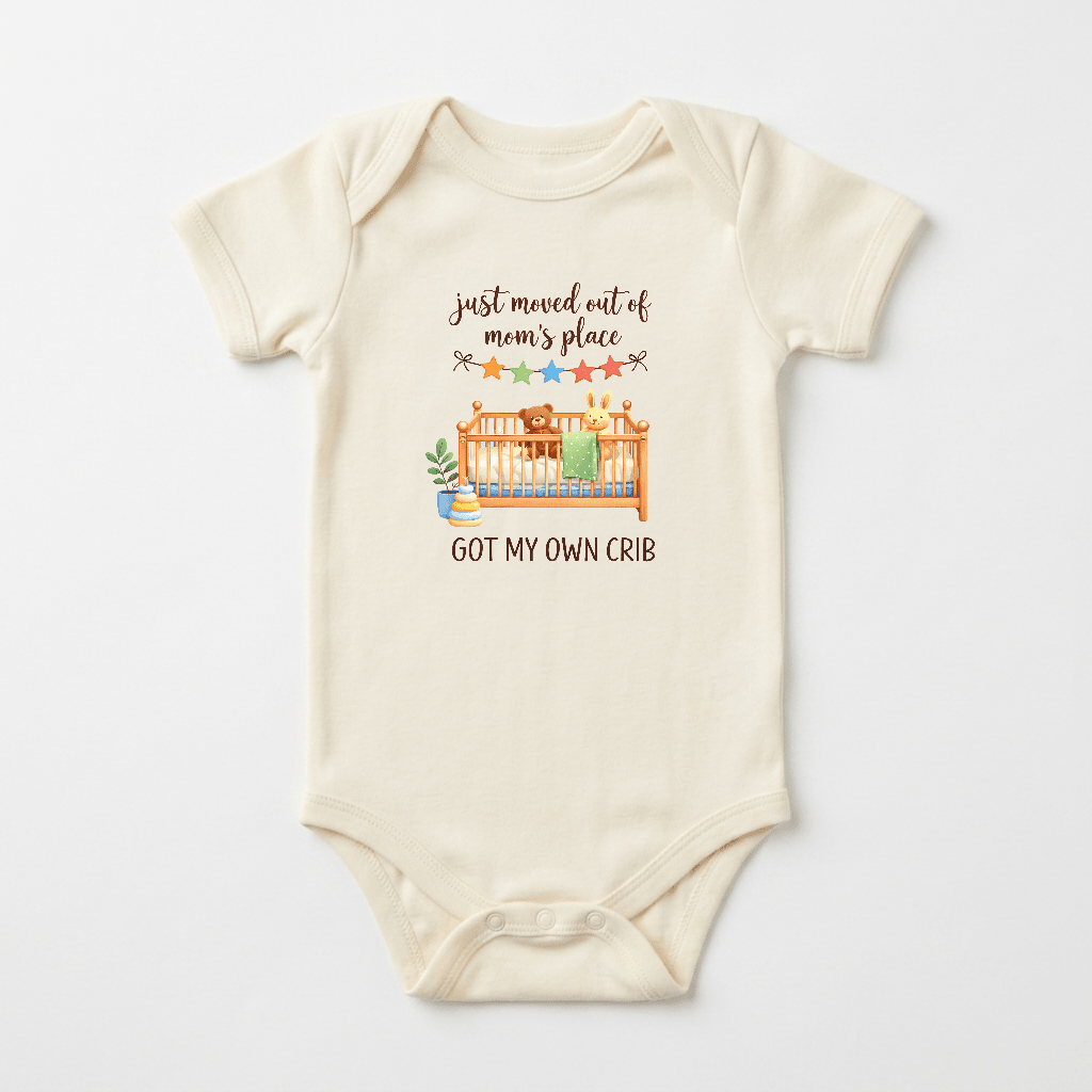The Toodleroos Funny Baby Onesie – Got My Own Crib Short-Sleeve Infant Bodysuit features a charming cream design with an illustrated crib, plants, and stars. The playful text reads “just moved out of mom’s place” above the crib and “GOT MY OWN CRIB” below, making it an adorable and humorous choice for a baby shower gift.