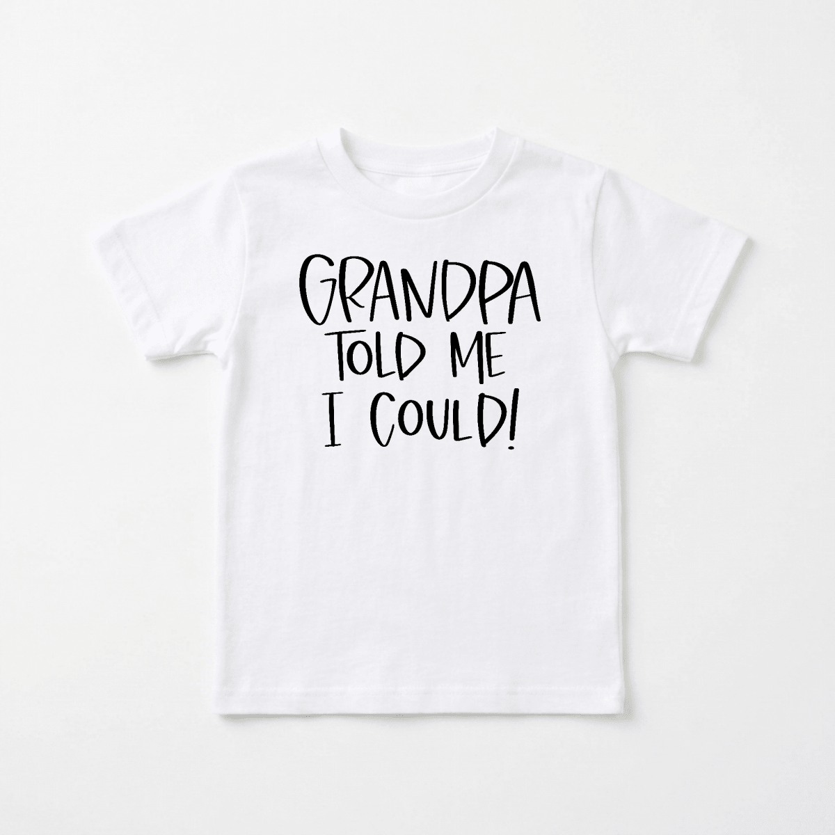 Toodleroos Grandpa Told Me I Could Toddler Shirt – Funny Family Tee in white, featuring bold black text that reads “GRANDPA TOLD ME I COULD!” is displayed on a flat, neutral background. This playful toddler shirt from Toodleroos makes an ideal gift for little ones or a humorous grandpa-themed tee perfect for family reunions.