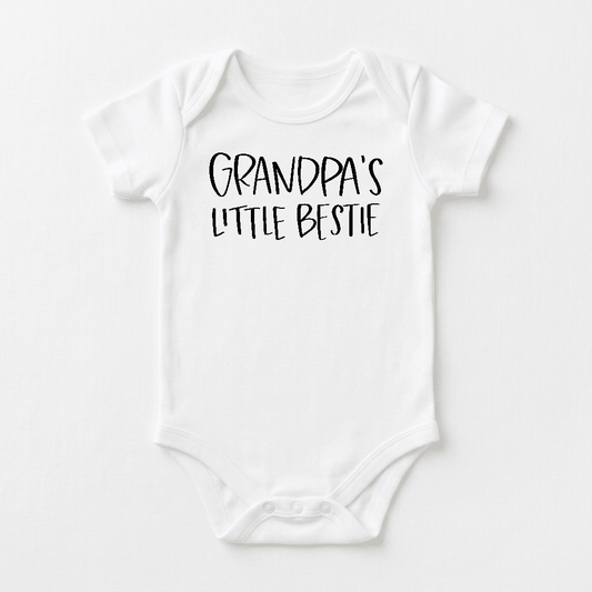 Dress your little one in the Toodleroos Grandpa’s Little Bestie Baby Onesie – a charming white bodysuit featuring “Grandpa’s Little Bestie” in bold, playful black lettering across the chest. This handwritten-style grandpa bodysuit is a delightful and heartwarming baby shower gift from Grandpa.