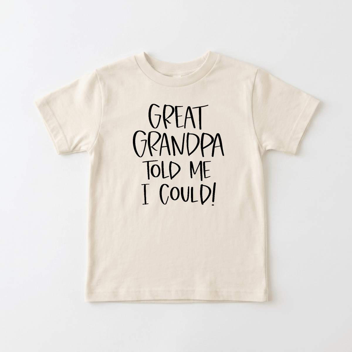 The Toodleroos Great Grandpa Told Me I Could Toddler Shirt – Funny Family Tee is a beige children’s T-shirt featuring bold black text that reads, “GREAT GRANDPA TOLD ME I COULD!” Displayed flat on a light background, this adorable tee makes a perfect gift from any great-grandpa and features a playful design kids will love.