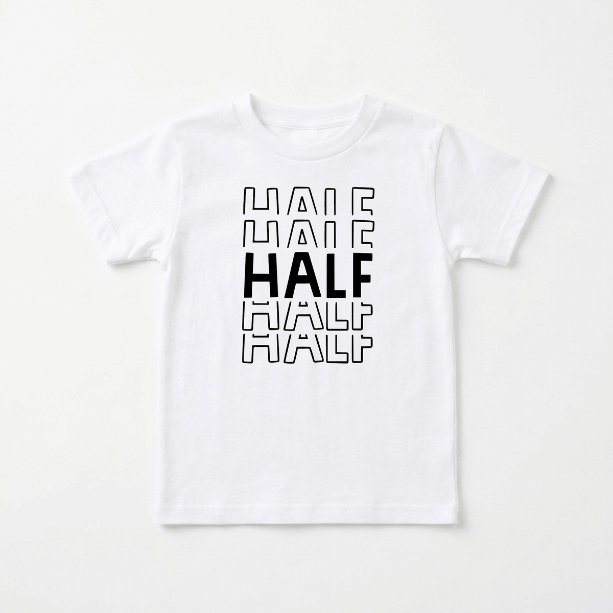 Introducing the Toodleroos Half Birthday Kids Shirt – 6 Month Milestone Tee. This black and white kids shirt features the word “HALF” printed three times vertically. The middle “HALF” is bold and solid black, while the top and bottom “HALF” are outlined in black. Perfect as a half birthday or milestone photo shirt, it’s ideal for capturing your child’s special moments.