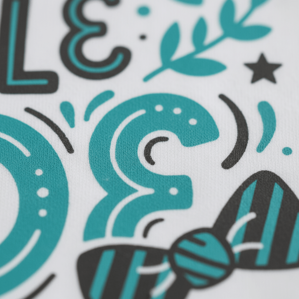 Close-up of a stylized teal and black graphic design on white fabric, showcasing bold curved shapes, dots, leaves, a star, and a striped bow tie detail—perfect for the Toodleroos Handsome Little Dude Baby Onesie – Dapper Bow Tie Bodysuit, an adorable choice for a baby boy or thoughtful baby shower gift.