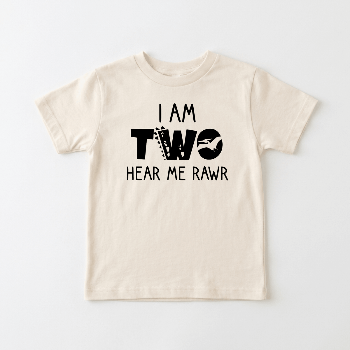 Introducing the Toodleroos I Am Two Hear Me Rawr Toddler Shirt – Dinosaur 2nd Birthday Tee: A beige children’s t-shirt featuring the playful text “I AM TWO HEAR ME RAWR” in bold black letters. The word “TWO” is decorated with fun patterns and a dinosaur silhouette, making this adorable tee the perfect choice for your little one’s second birthday celebration!.