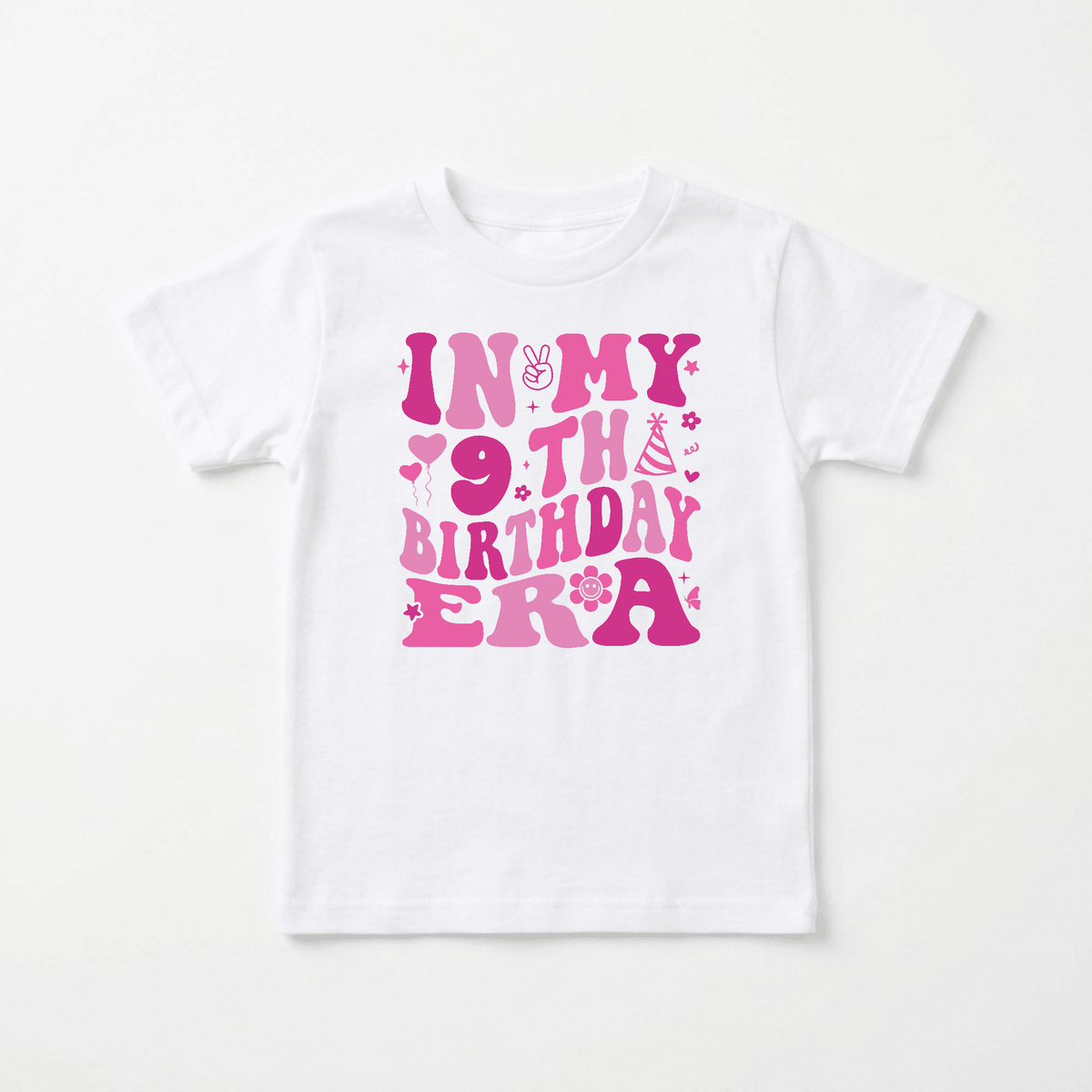 The Toodleroos In My 9th Birthday Era Kids Shirt – Retro 9th Birthday Tee showcases bold, bright pink text in large, playful letters, decorated with a peace sign, smiley face, party hat, stars, and flowers. This fun shirt is the perfect way for kids to celebrate their special day in style!.